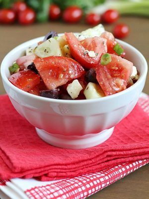 Greek Tomato Salad | easy salad made with tomatoes, cucumbers, olives, green onions & feta cheese and tossed with a homemade dressing. Light and delicious!