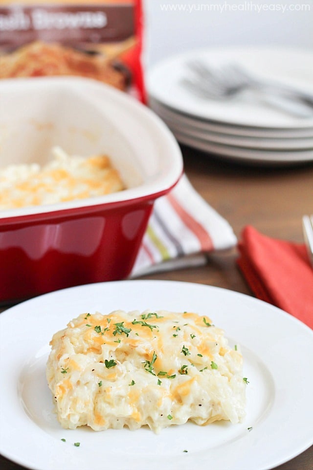 Potato Casserole piece on a plate with a casserole dish in the background.