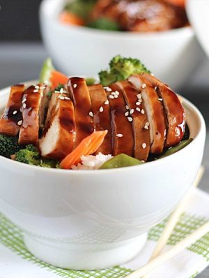 Delicious Chicken Teriyaki Bowls with chicken baked in a homemade teriyaki sauce layered on top of a bed of rice & veggies!