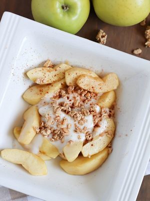 Baked Apples tossed in maple syrup and served with spiced yogurt and granola. Easy and healthy dessert, snack or breakfast!