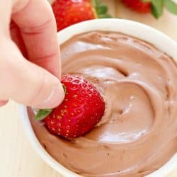 Bright red strawberry is dunked into a creamy Chocolate Yogurt Dip + 43 Healthy Snack Ideas