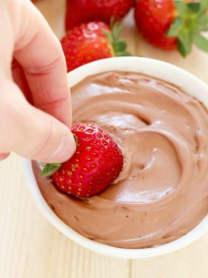Bright red strawberry is dunked into a creamy Chocolate Yogurt Dip + 43 Healthy Snack Ideas