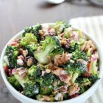 Need an easy side dish? Make this Creamy Broccoli Salad! It's full of fresh broccoli, red onion, dried cranberries, sunflower seeds and bacon mixed in a creamy, delicious dressing. Always a hit!