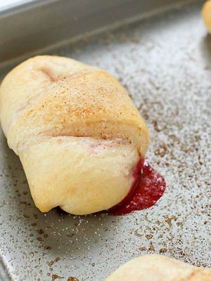 Need a quick and easy dessert? Try these Strawberry Cheesecake Rolls! Crescent rolls spread with a cream cheese mixture and a scoop of strawberries rolled together and baked. Delicious!