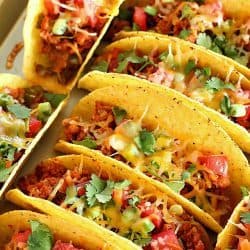 Ground Turkey Tacos that are oven-baked with layers of deliciousness inside! Refried beans, ground turkey taco meat, (no taco seasoning mix!) tomato, cilantro, green onions and cheese all baked in taco shells. Perfect for Taco Tuesday or for game day!
