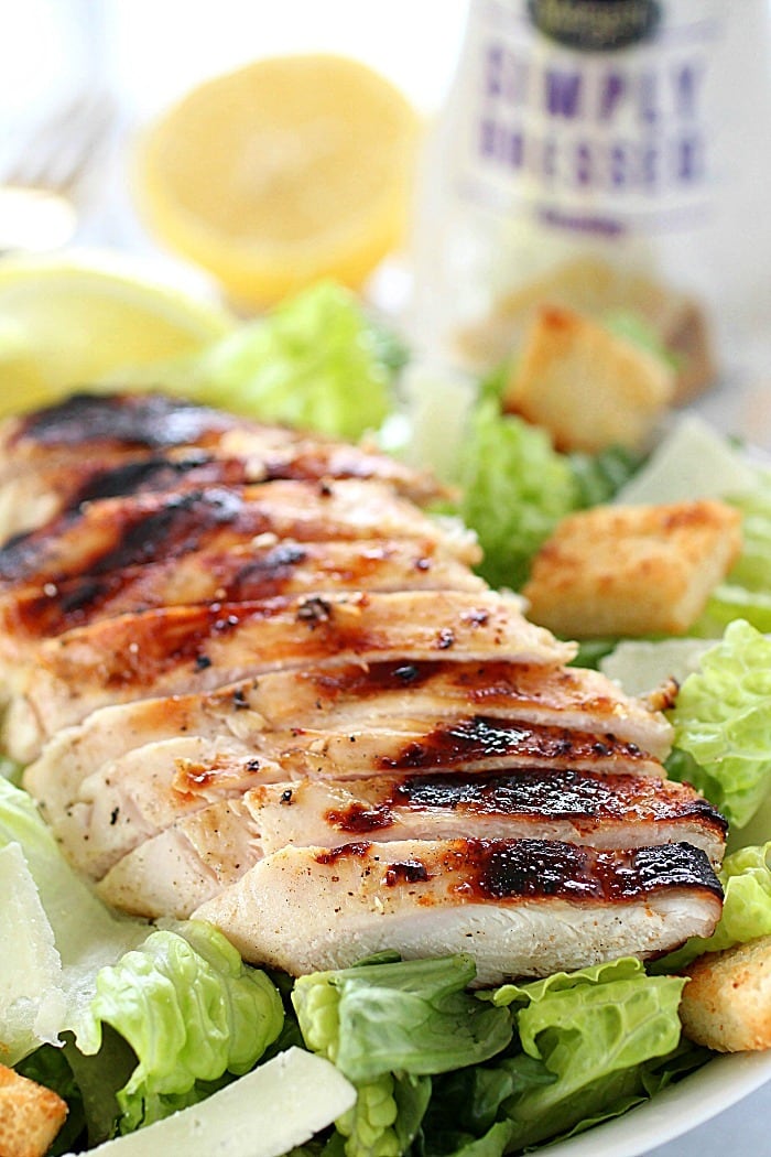 Grilled Chicken Caesar Salad for a yummy summertime lunch or dinner! With a simple yogurt marinade recipe, this grilled chicken is tender and delicious. Served over romaine lettuce, homemade croutons, shaved parmesan and caesar dressing - YUM!! AD