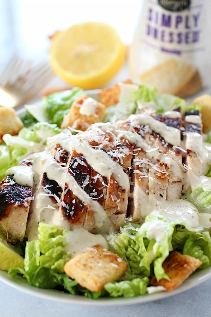 Grilled Chicken Caesar Salad for a yummy summertime lunch or dinner! With a simple yogurt marinade recipe, this grilled chicken is tender and delicious. Served over romaine lettuce, homemade croutons, shaved parmesan and caesar dressing - YUM!! AD