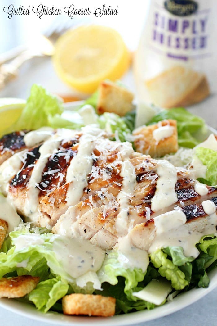 Grilled Chicken Caesar Salad for a yummy summertime lunch or dinner! With a simple yogurt marinade recipe, this grilled chicken is tender and delicious. Served over romaine lettuce, homemade croutons, shaved parmesan and caesar dressing - YUM!! AD