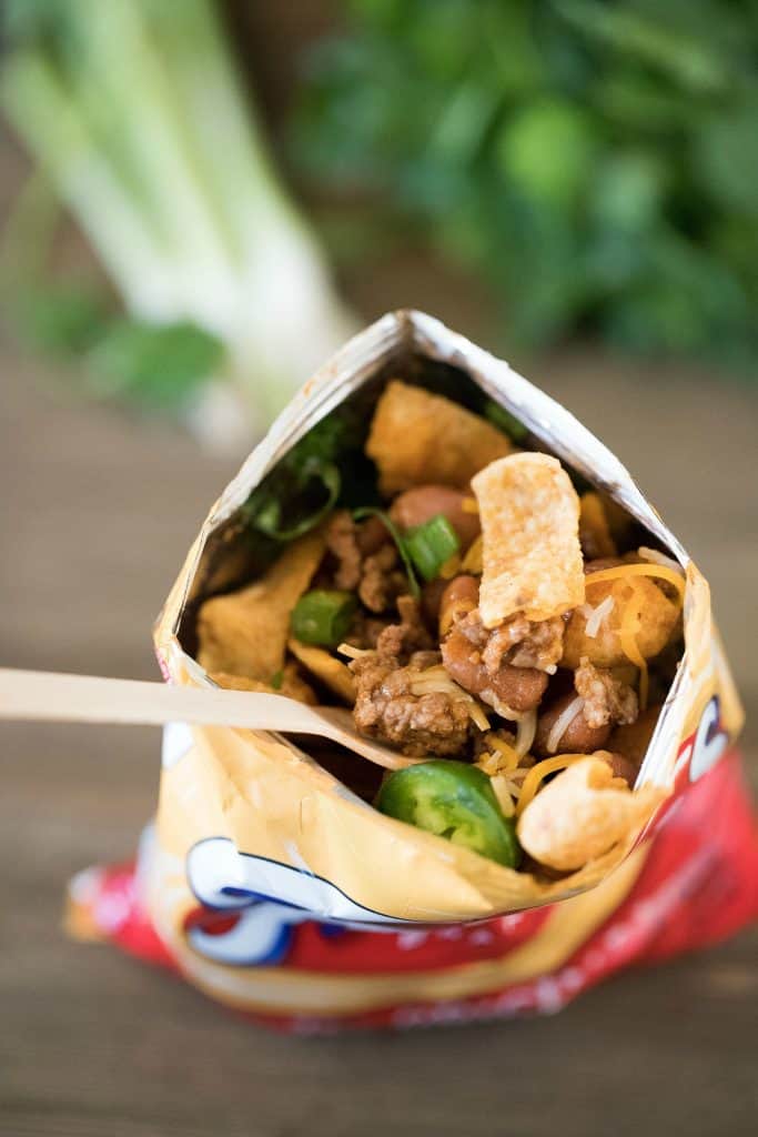 Top view of a Frito's bag filled with taco filling and toppings.