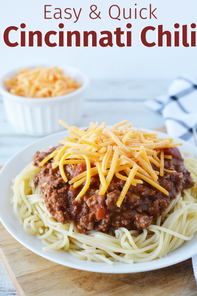 Plate with spaghetti noodles topped with chili and shredded cheese.